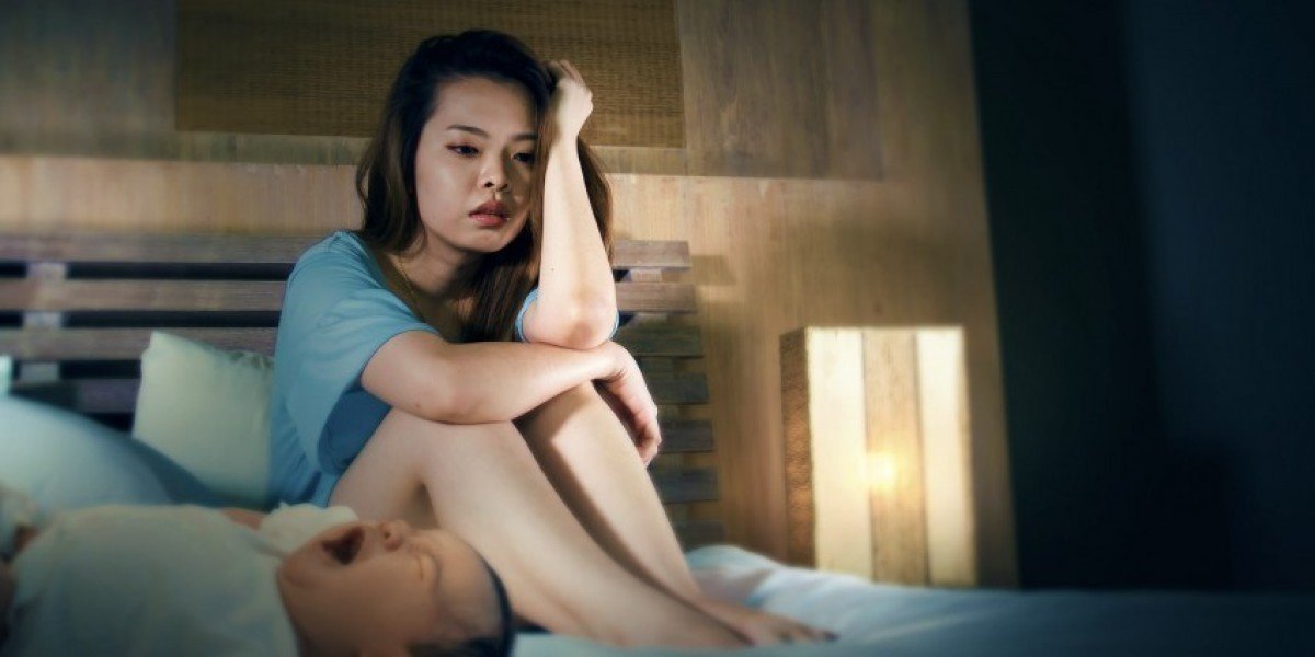 Stressed and helpless mummy with a crying baby on the bed. 